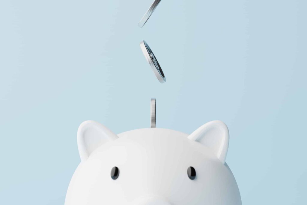 Here Are 2 Dividend Stocks I’d Hold in My TFSA for 20 Years Silver coins fall into a piggy bank.