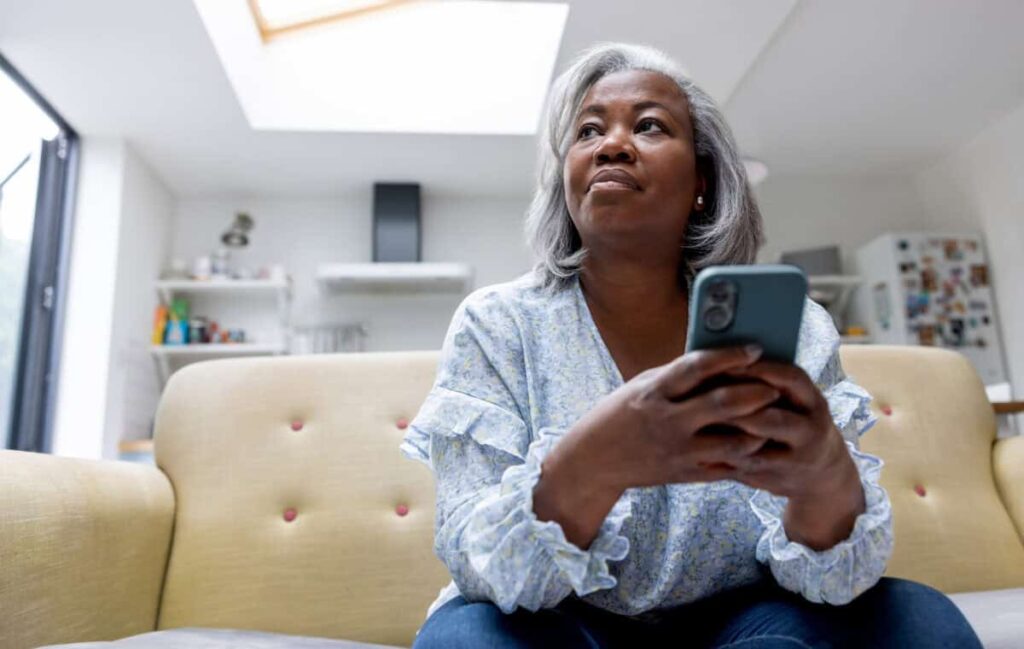 Here Are 5 Stocks I Think Every Canadian Should Own woman looks at iPhone