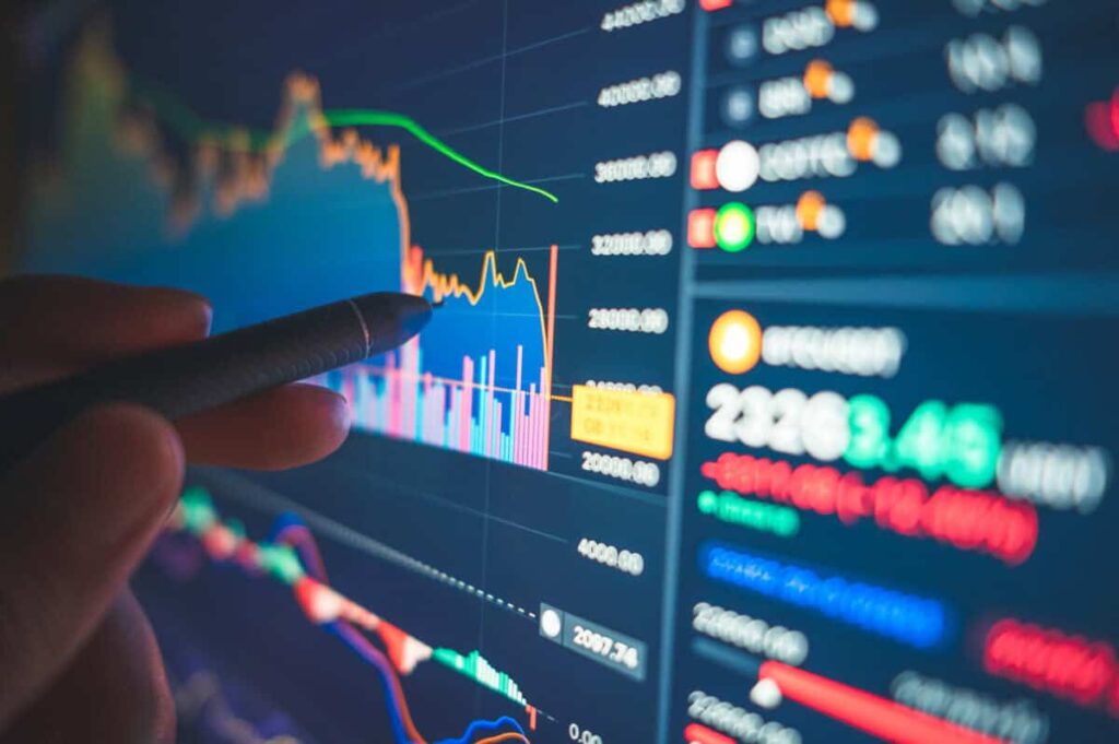 Financial analyst reviews numbers and charts on a screen